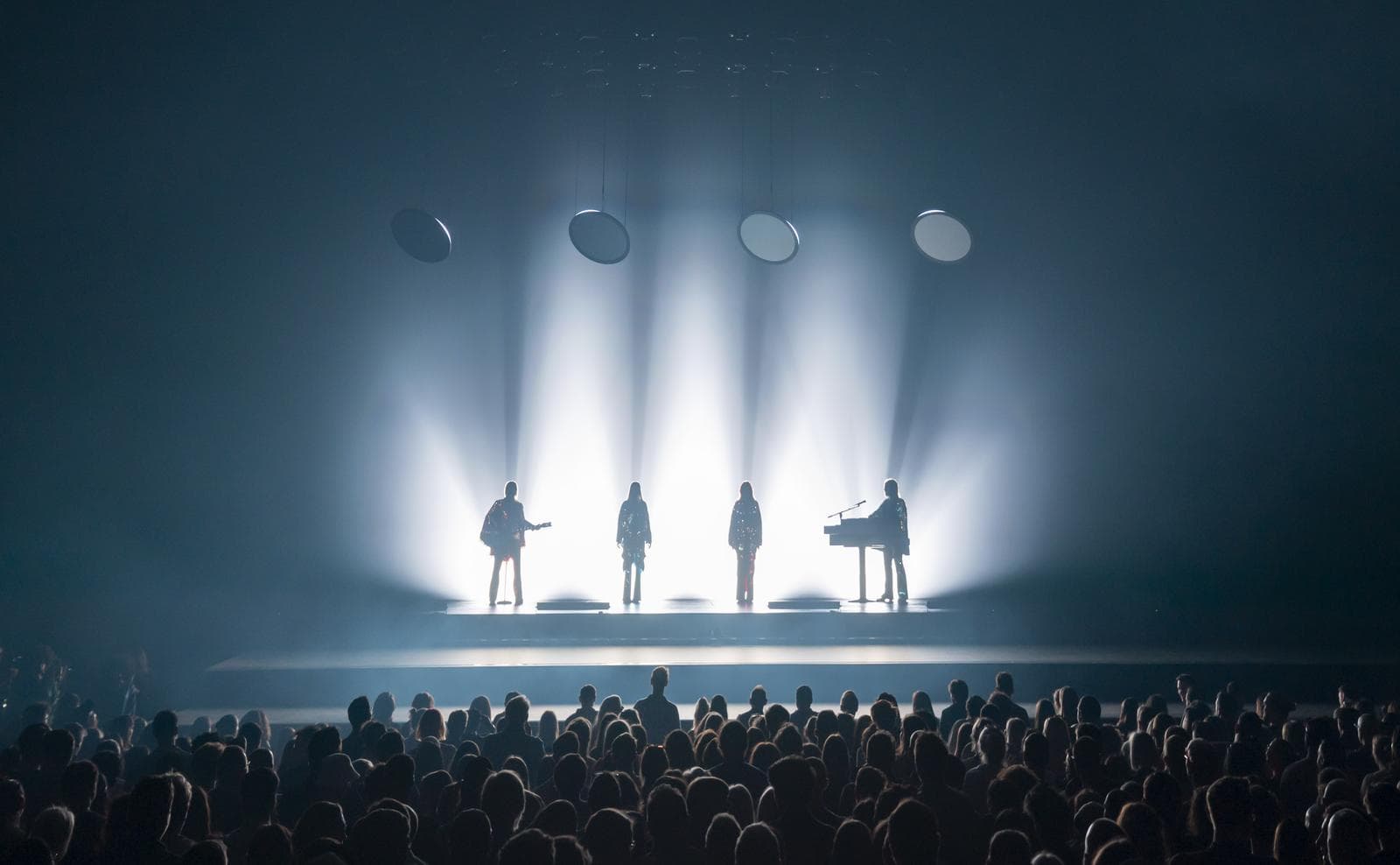 ABBA Voyage, ABBA Arena, London mit Lichteffekten, Publikum im Vordergrund, dunkle Atmosphäre.