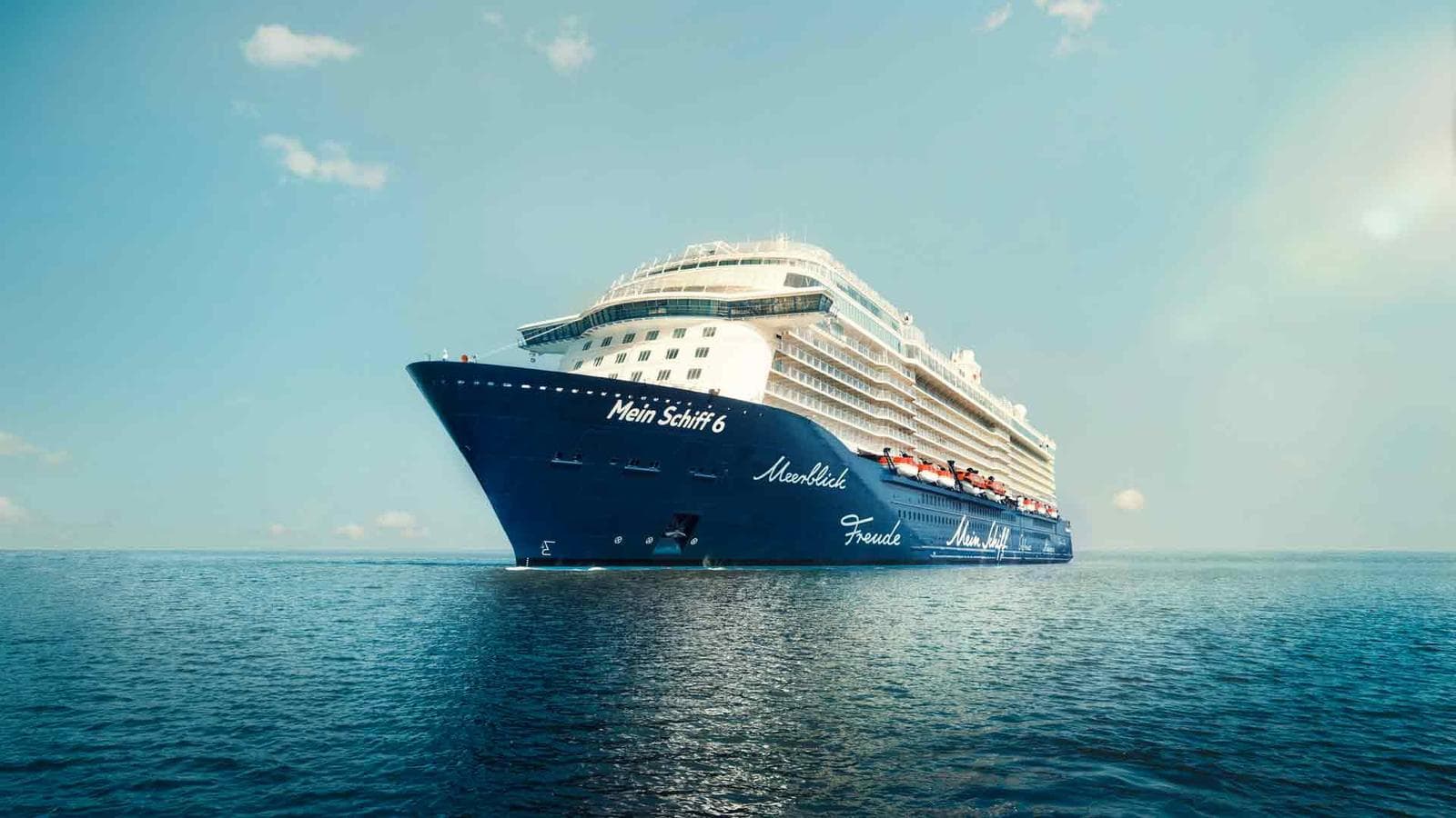 Kreuzfahrtschiff "Mein Schiff 6" auf ruhiger See unter blauem Himmel.