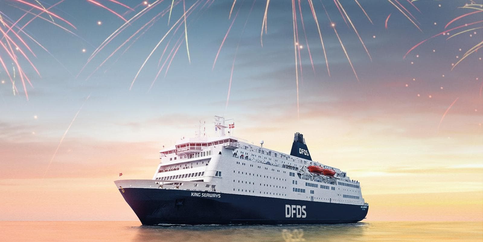 Große Fähre auf ruhigem Meer bei Sonnenaufgang, mit Feuerwerk am klaren Himmel.