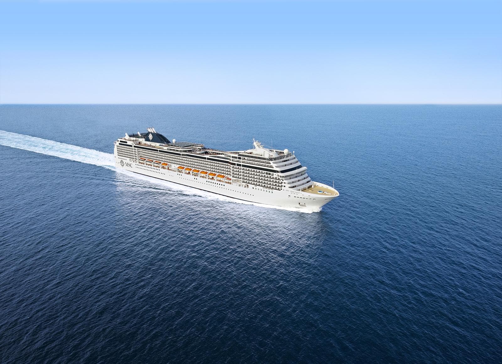 Ein großes Kreuzfahrtschiff fährt ruhig über das tiefblaue offene Meer.