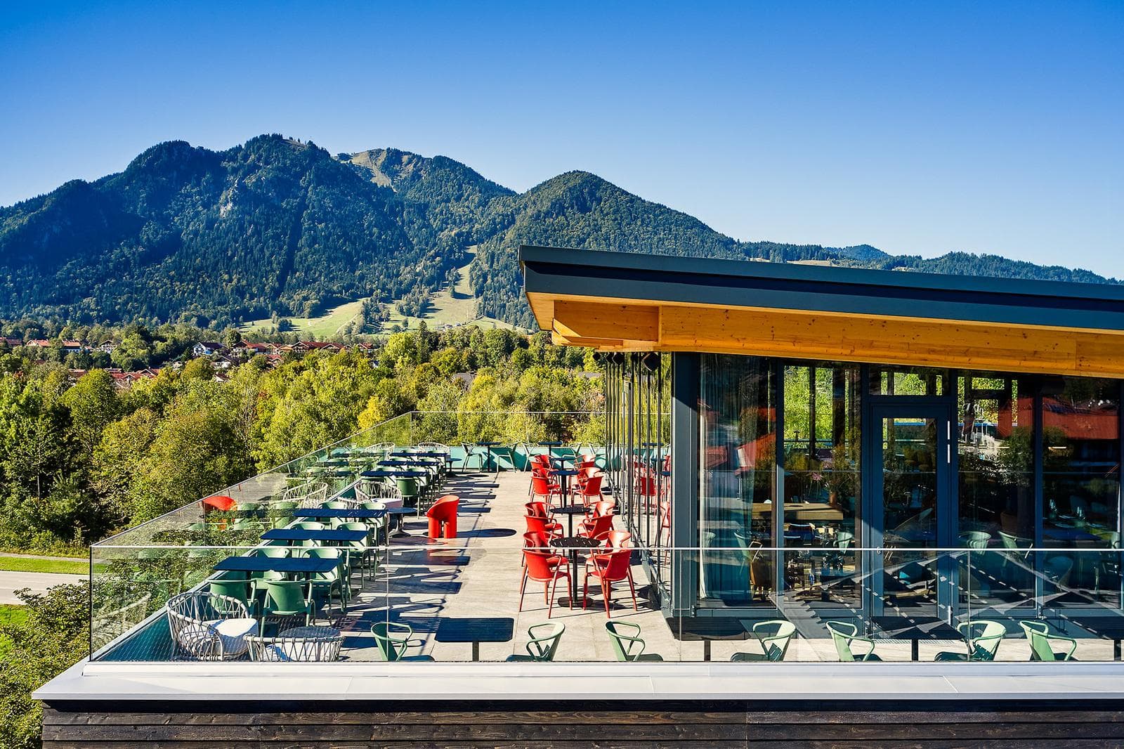 Moderne Dachterrasse eines Restaurants mit Panoramablick auf die bayerischen Alpen.
