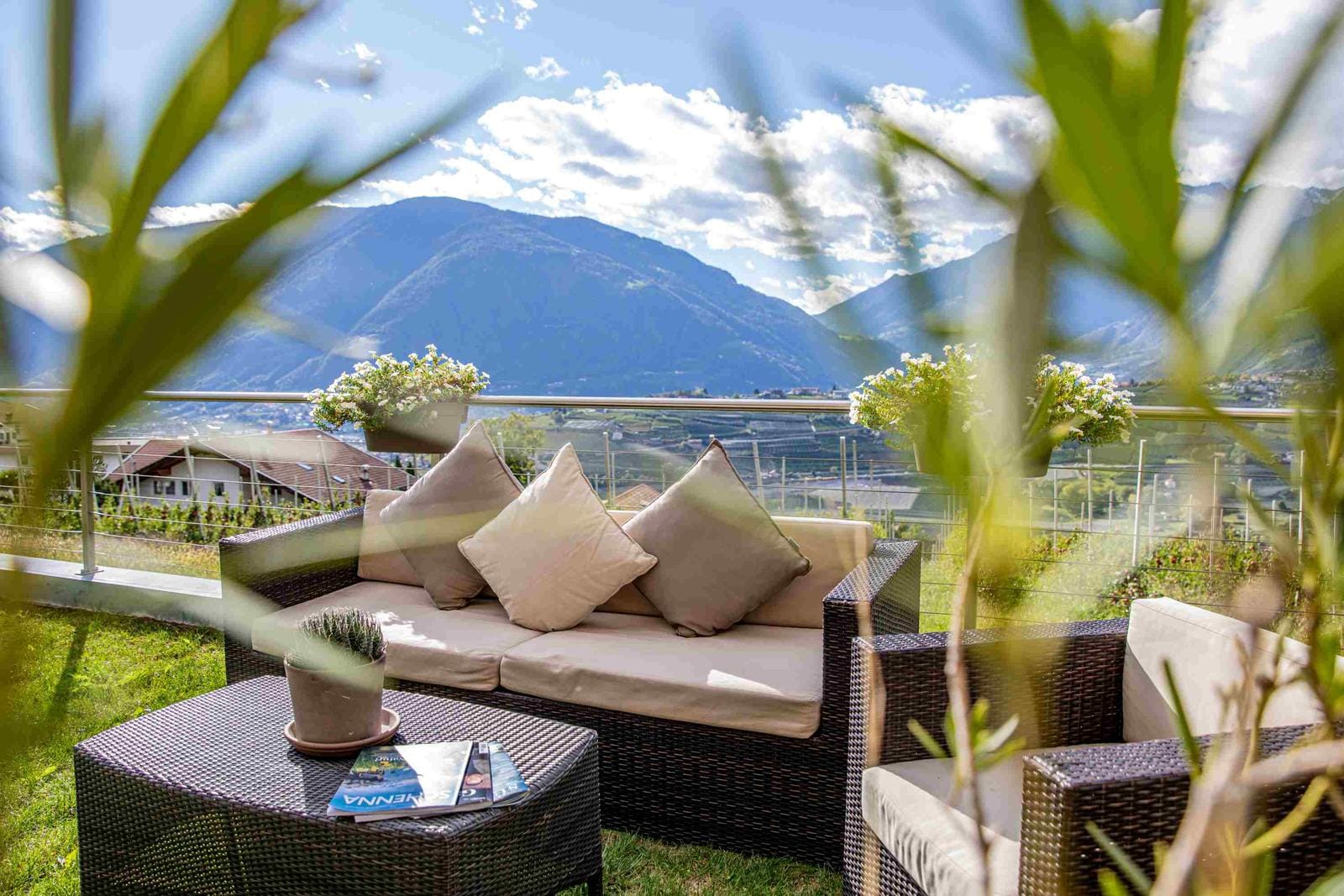 Gemütliche Terrasse mit Rattanmöbeln, Bergblick im Hintergrund, harmonisch und einladend.