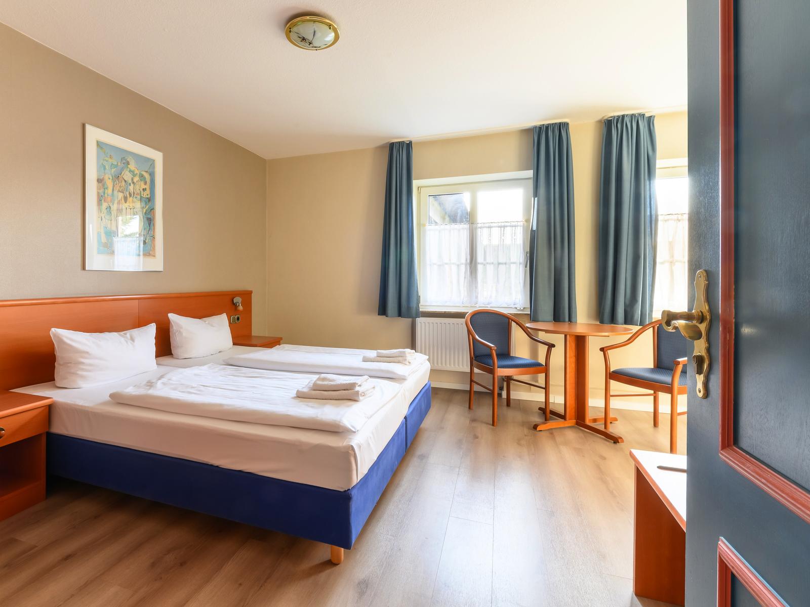 Helles Hotelzimmer mit gemütlichem Doppelbett.