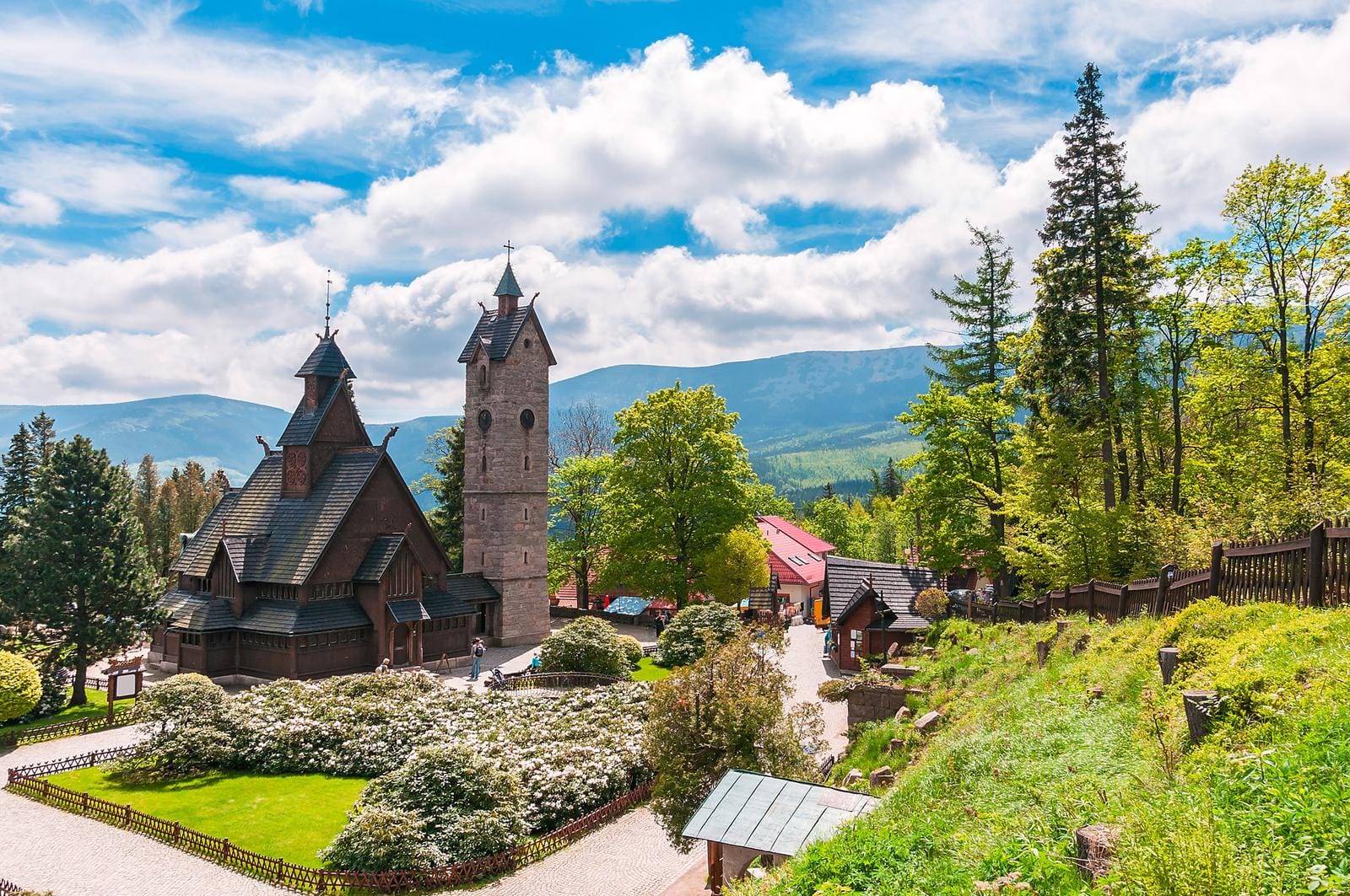 Stabkirche Wang in Karpacz, Polen, vor den grünen Bergen und blauem Himmel.