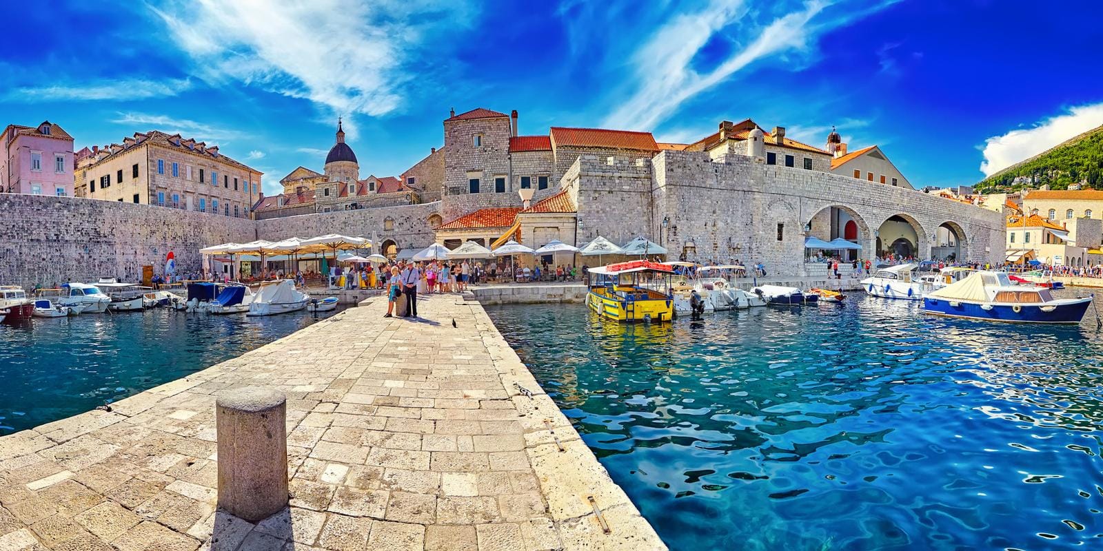Historischer Hafen in Dubrovnik, Kroatien, mit Booten vor mittelalterlichen Mauern.