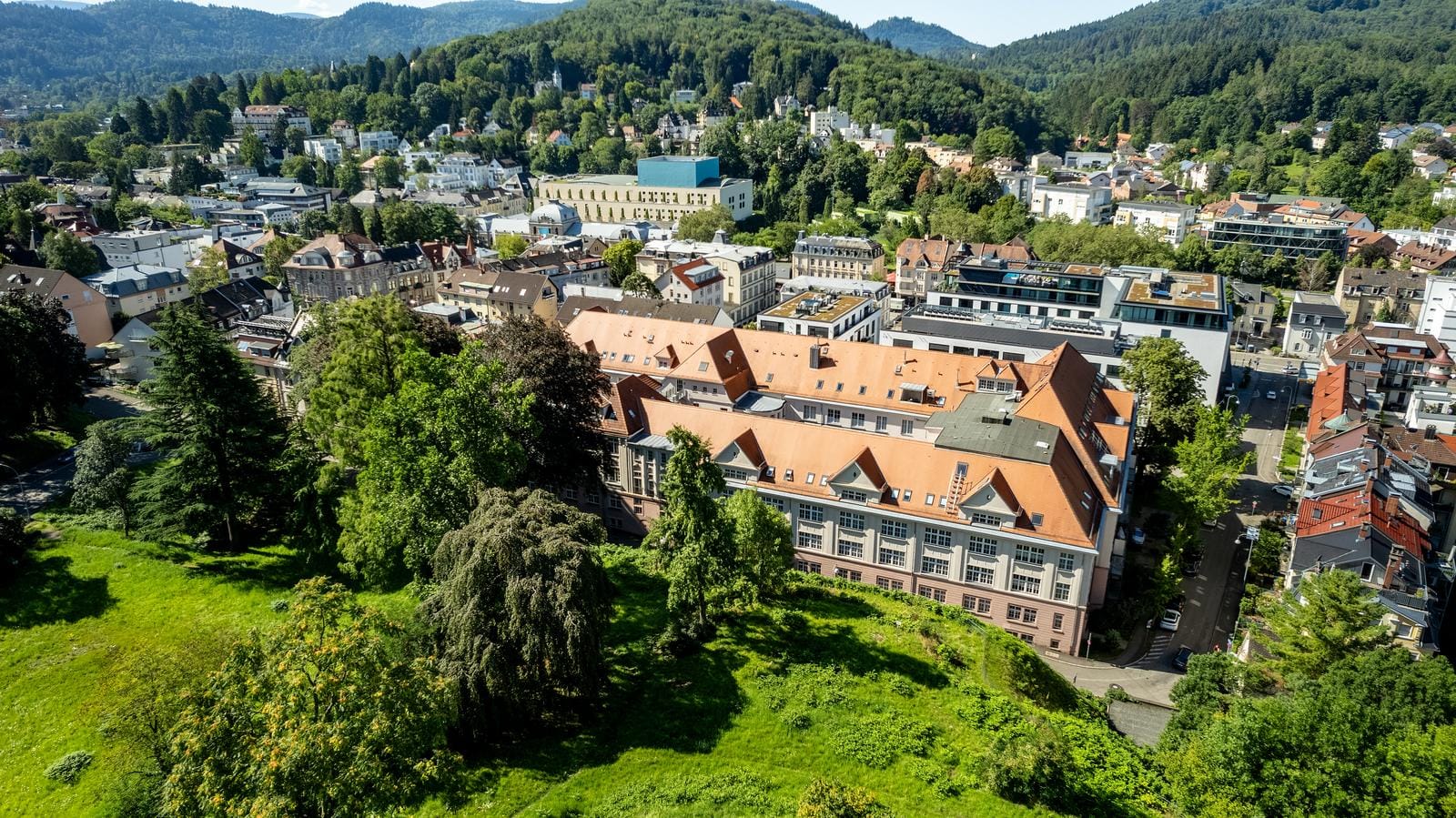 Luftaufnahme von Baden-Baden, Deutschland, mit grünen Hügeln und historischer Architektur.