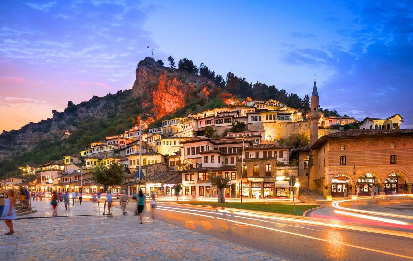 Bergstädtchen bei Dämmerung in Berat, Albanien, mit historischen Häusern an einem Hang.