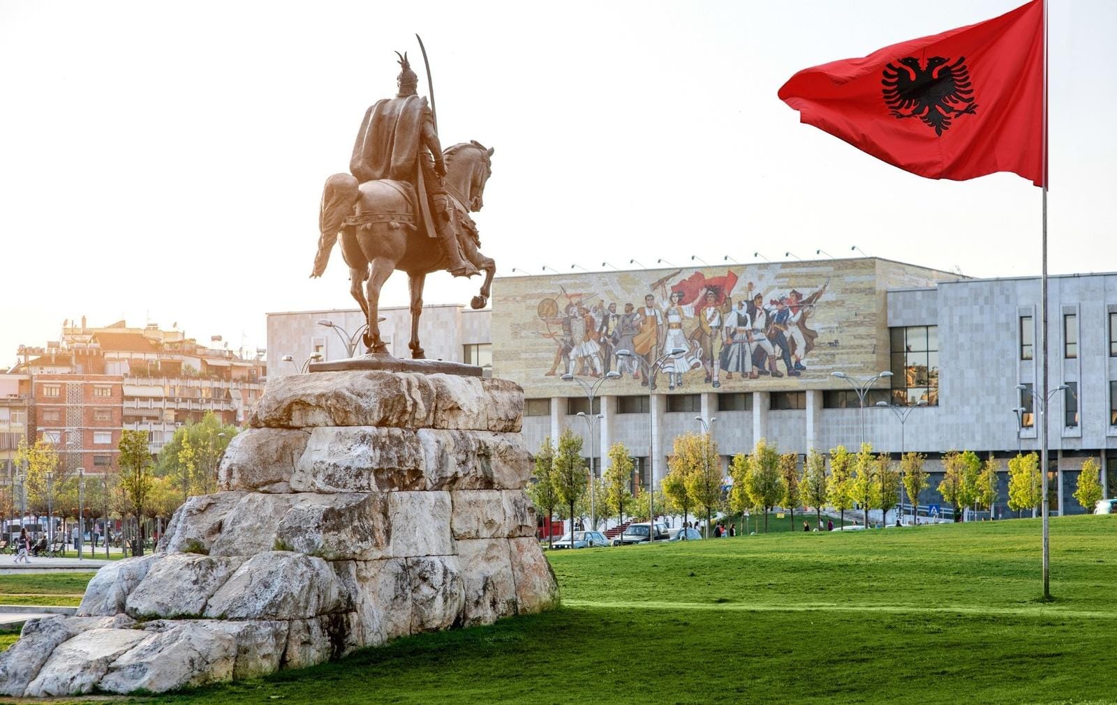 Reiterdenkmal in Tirana, Albanien vor Nationalmuseum und albanischer Flagge.