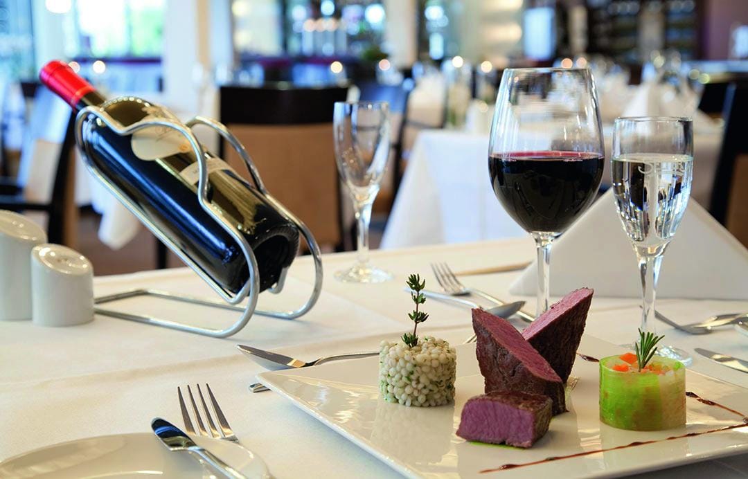 Feines Dinner mit Rotwein und edlen Speisen im Ambassador Hotel & Spa