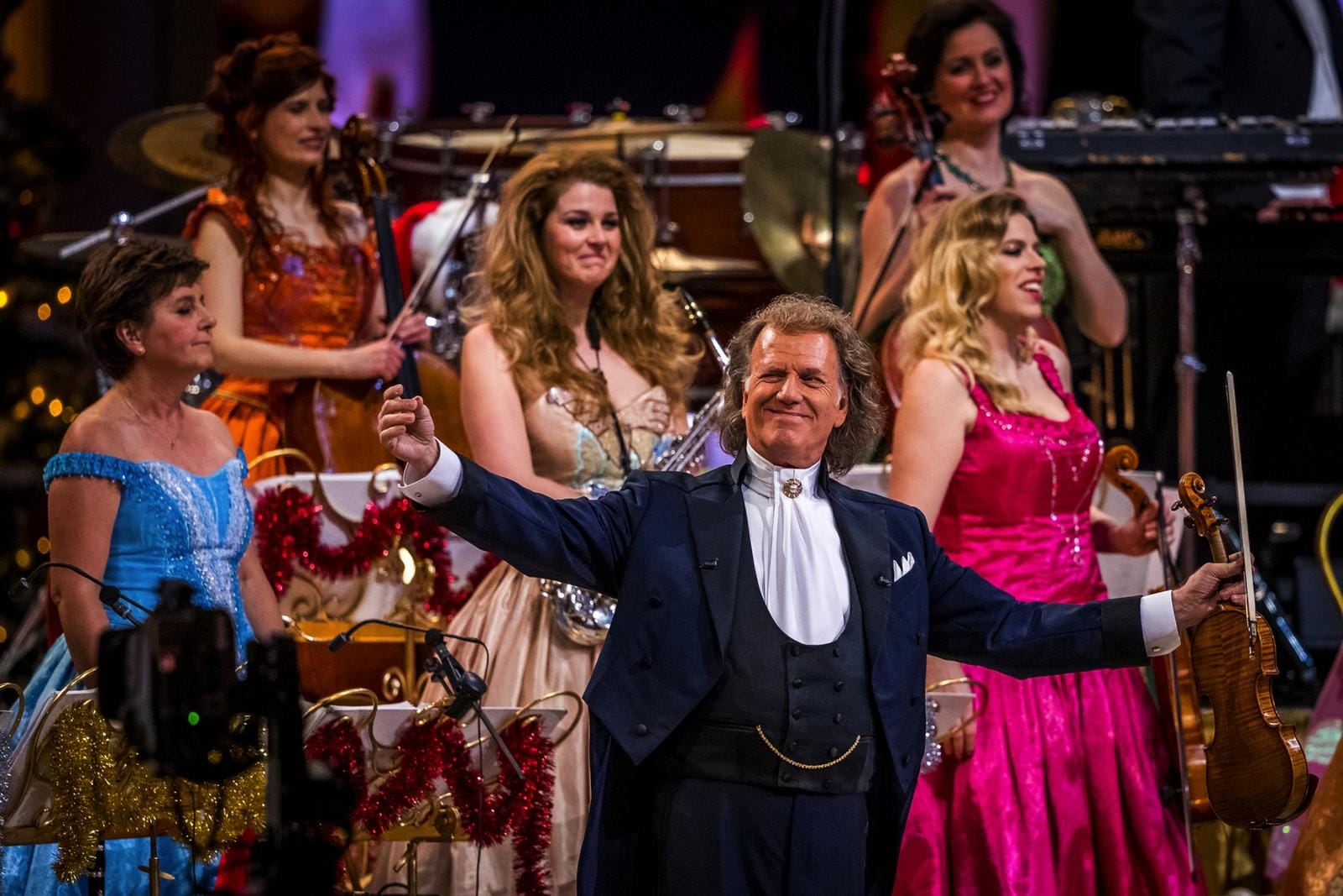 Ein Konzertabend: Andre Rieu in eleganter Kleidung genießen die Musik mit einem Orchester.