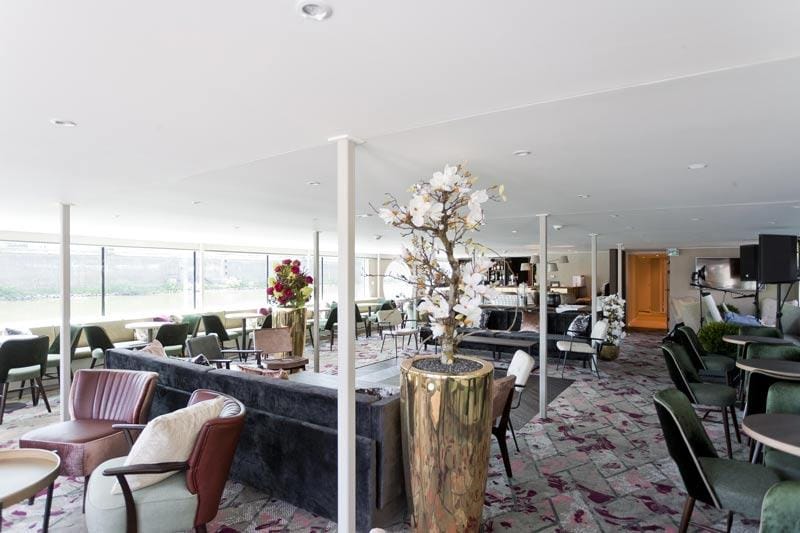 Helle Hotel-Lobby mit modernen Sitzmöbeln, großen Fenstern und eleganter Dekoration.