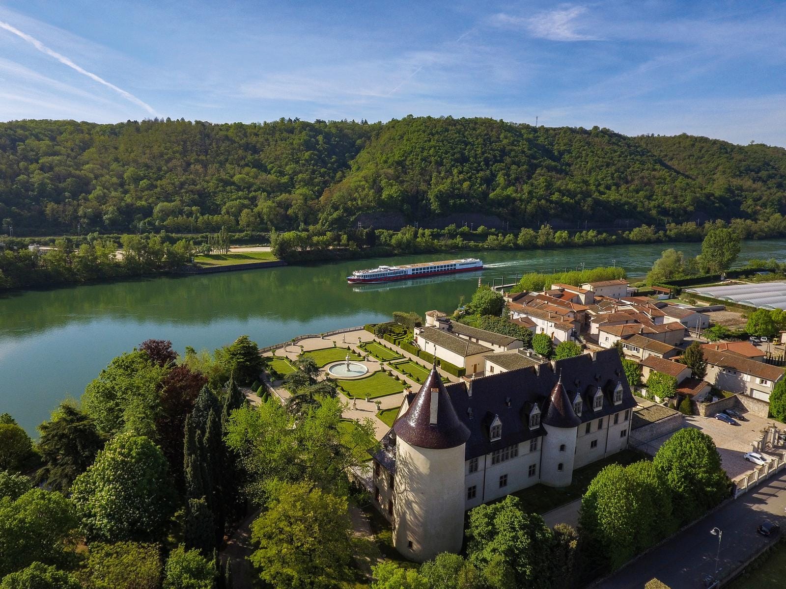 Flusslandschaft in Frankreich mit Schloss und vorbeifahrender Bijou DU RHONE