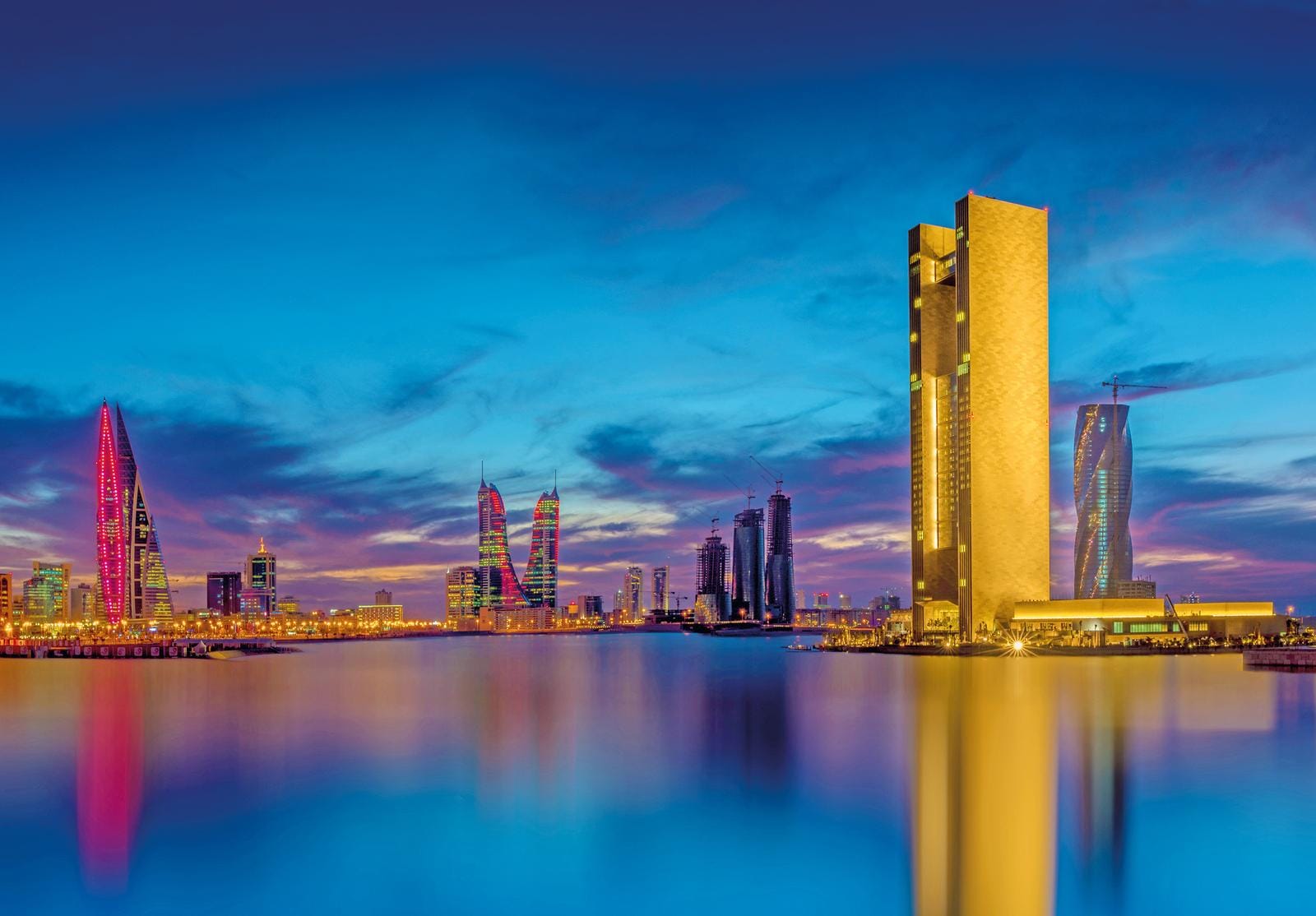 Blick auf die beeindruckende Skyline von Manama, Bahrain, bei farbenfrohem Sonnenuntergang.