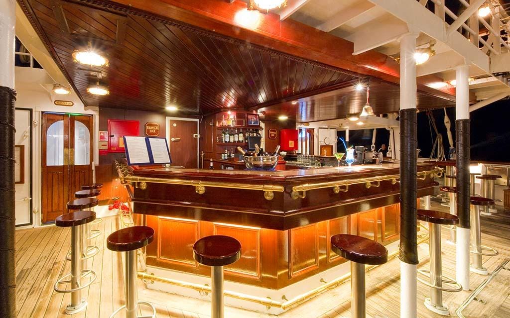 Schicke Holzbar auf einem Schiff, mit Metallhockern und stimmungsvoller Beleuchtung.