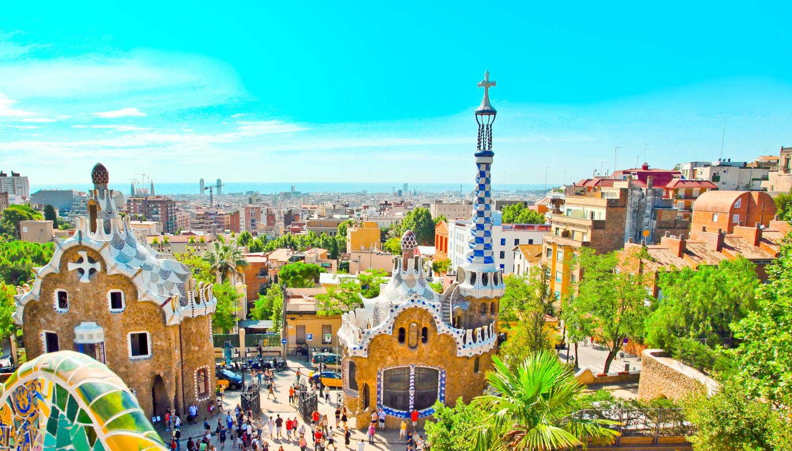 Bunte, geschwungene Architektur von Park Güell in Barcelona, Spanien unter blauem Himmel.
