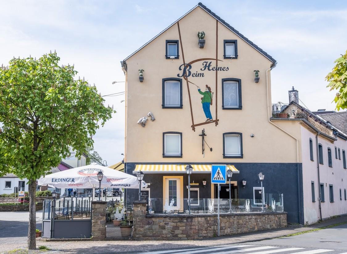 Historische Gaststätte mit bemalter Fassade und gemütlicher Außenterrasse in Deutschland.