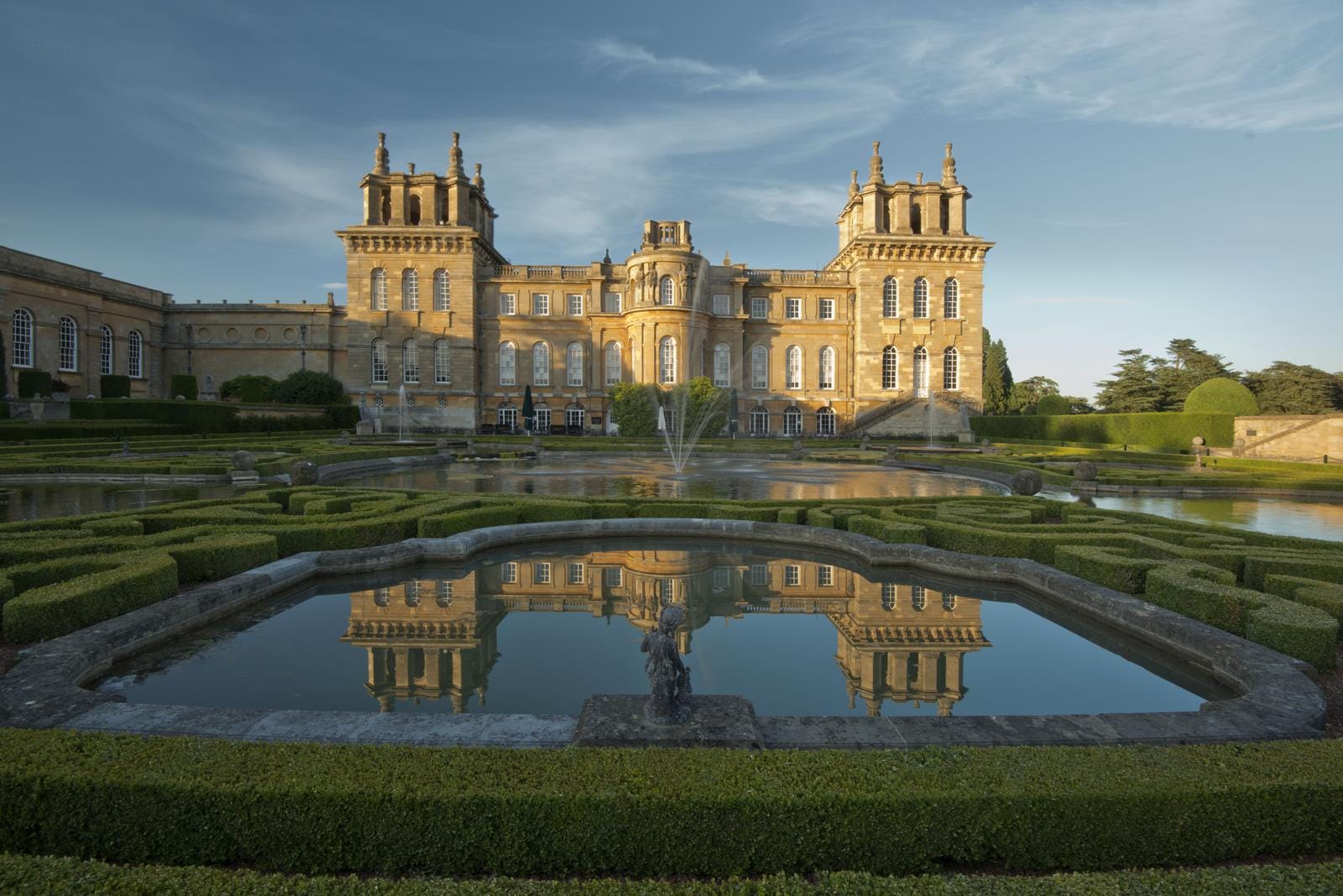 Prachtvolles englisches Schloss mit kunstvoll angelegtem Garten und Wasserbecken.