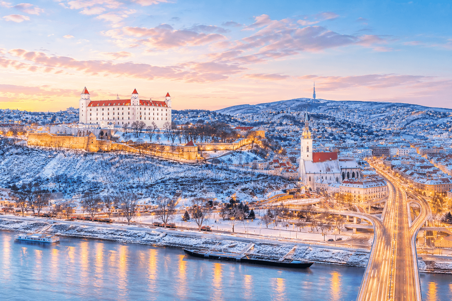 Winterliches Panorama von Bratislava, Slowakei, mit Schloss und beleuchteter Altstadt.
