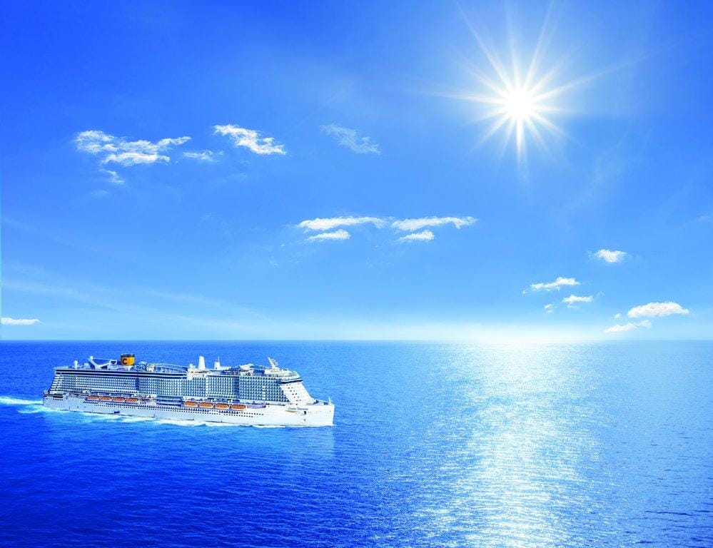 Kreuzfahrtschiff auf blauem Meer unter strahlendem Sonnenschein und klarem Himmel.