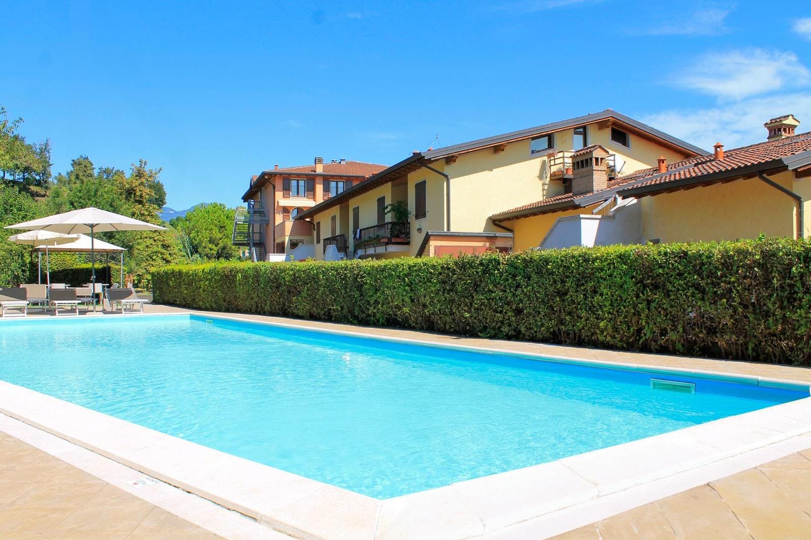 Ein sonniger Tag in einem italienischen Ferienhaus mit Pool und malerischer Umgebung.