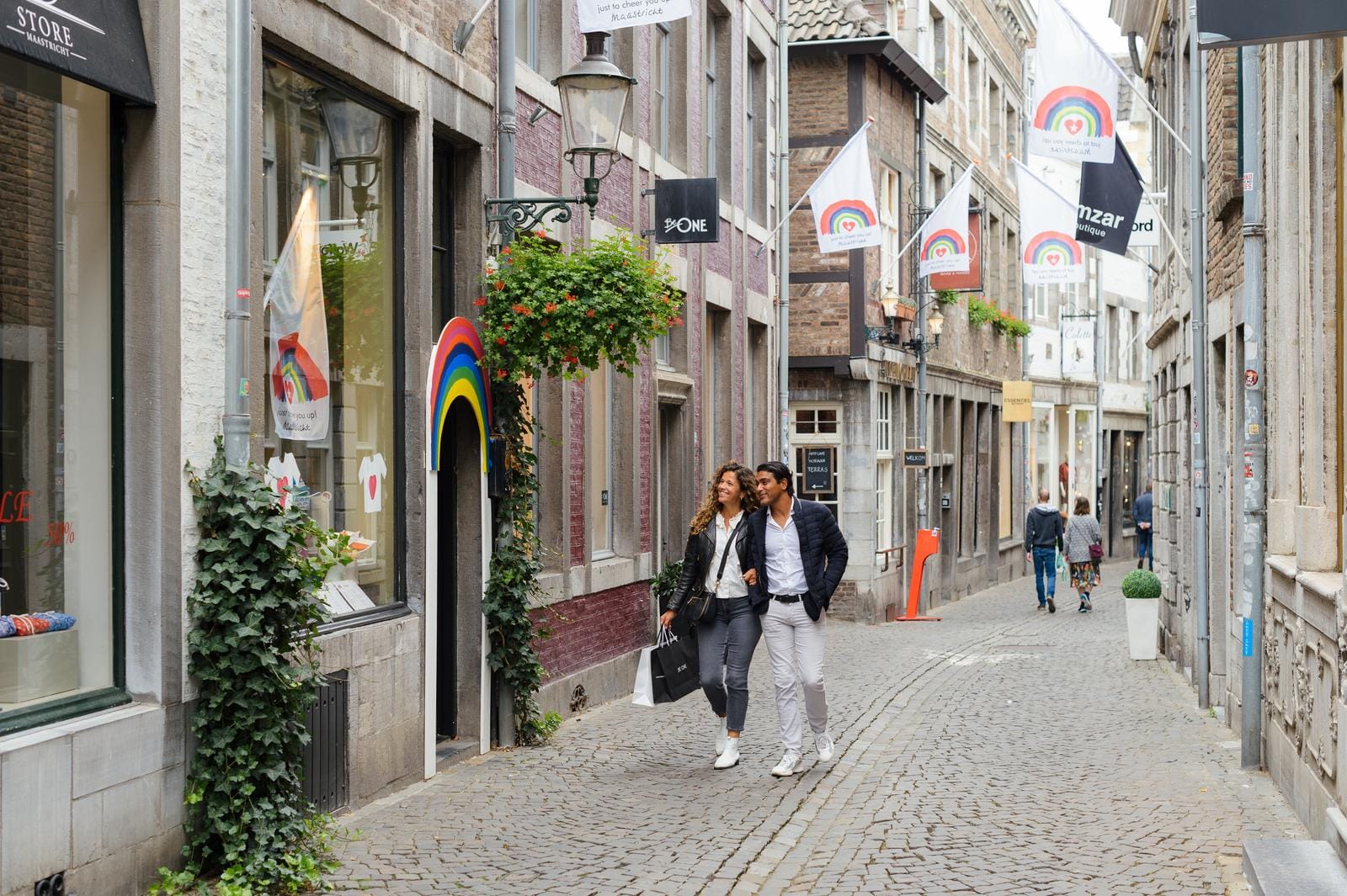 Paar spaziert durch malerische Kopfsteinpflasterstraße in Maastricht, Niederlande.
