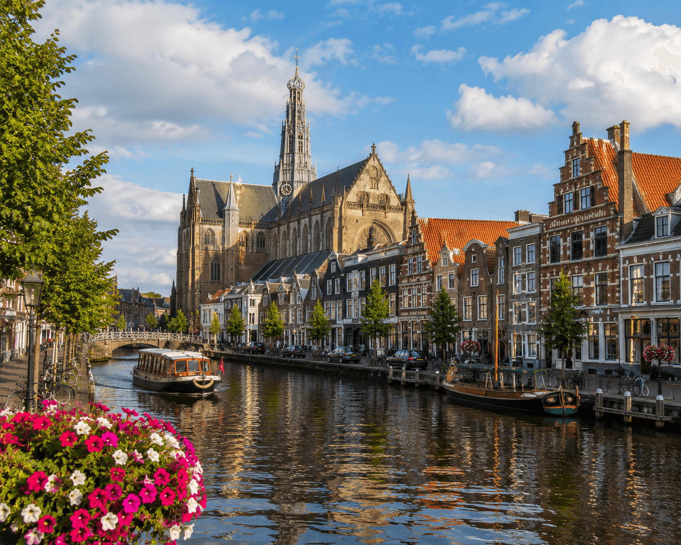 Historische Kirche und Kanal mit Booten in Haarlem, Niederlande, bei sonnigem Wetter.