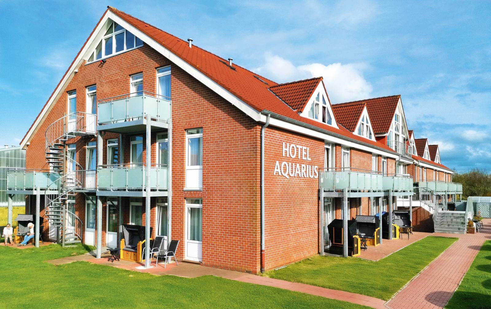 Gemütliches Backsteinhotel mit roten Dächern und Balkonen