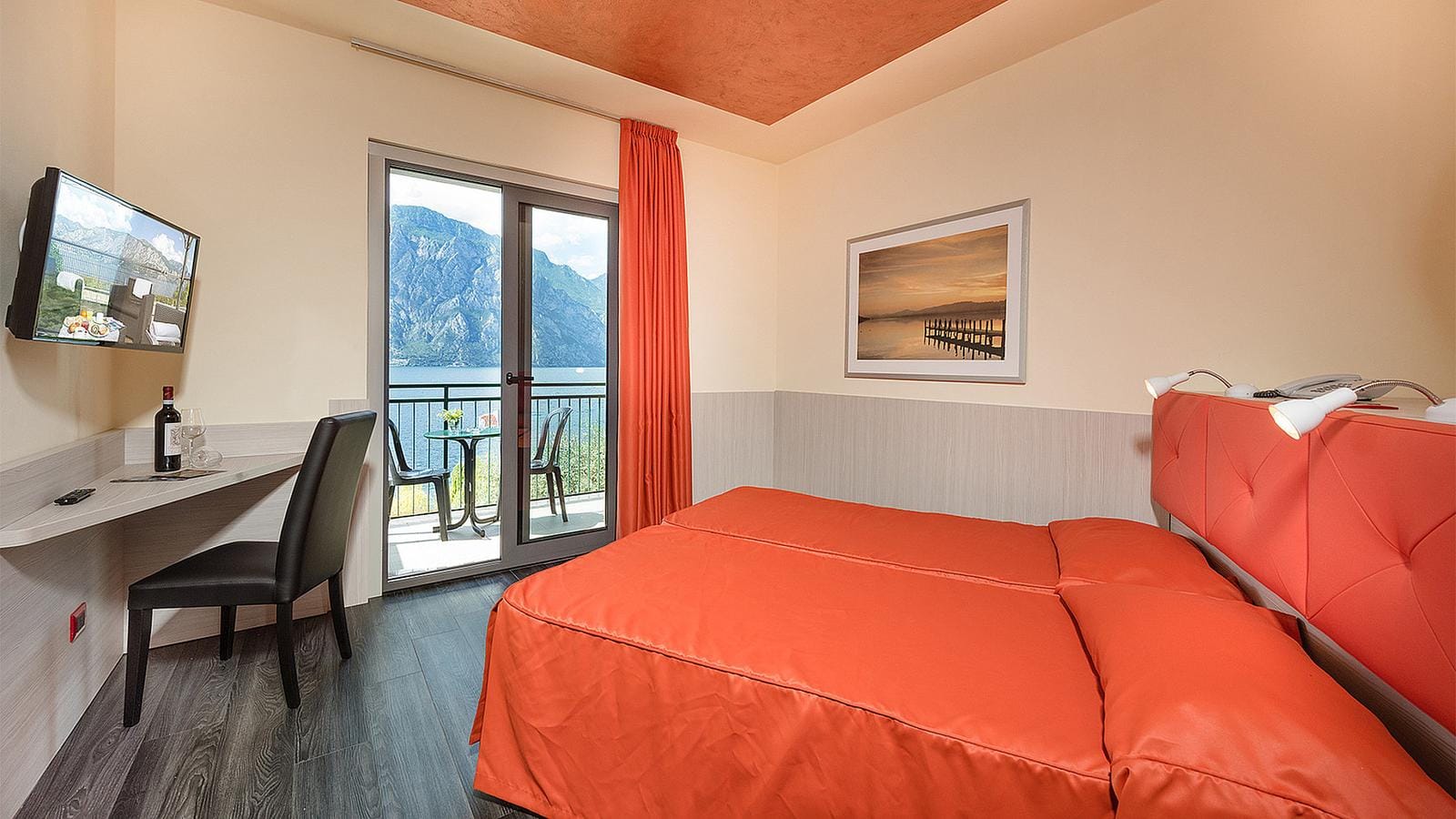 Modernes Hotelzimmer mit Balkonblick auf Berge, helle Wände.