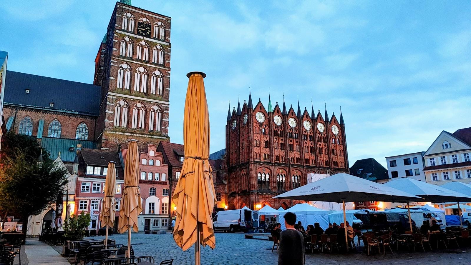 Historischer Marktplatz in Stralsund mit Rathaus und Marienkirche bei Abenddämmerung.