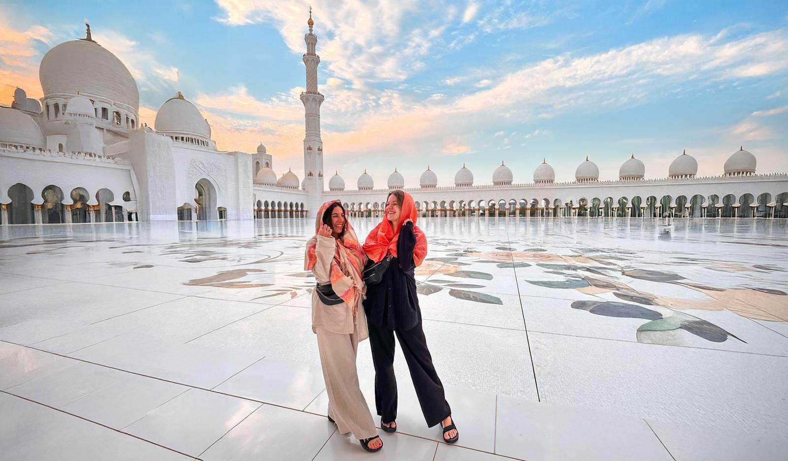 Scheich-Zayid-Moschee, Abu Dhabi, mit verziertem Marmorboden und blauer Himmelskulisse.