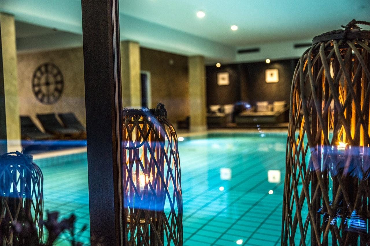 Entspannendes Hotel-Spa mit beleuchtetem Indoor-Pool und eleganten Sitzgelegenheiten.
