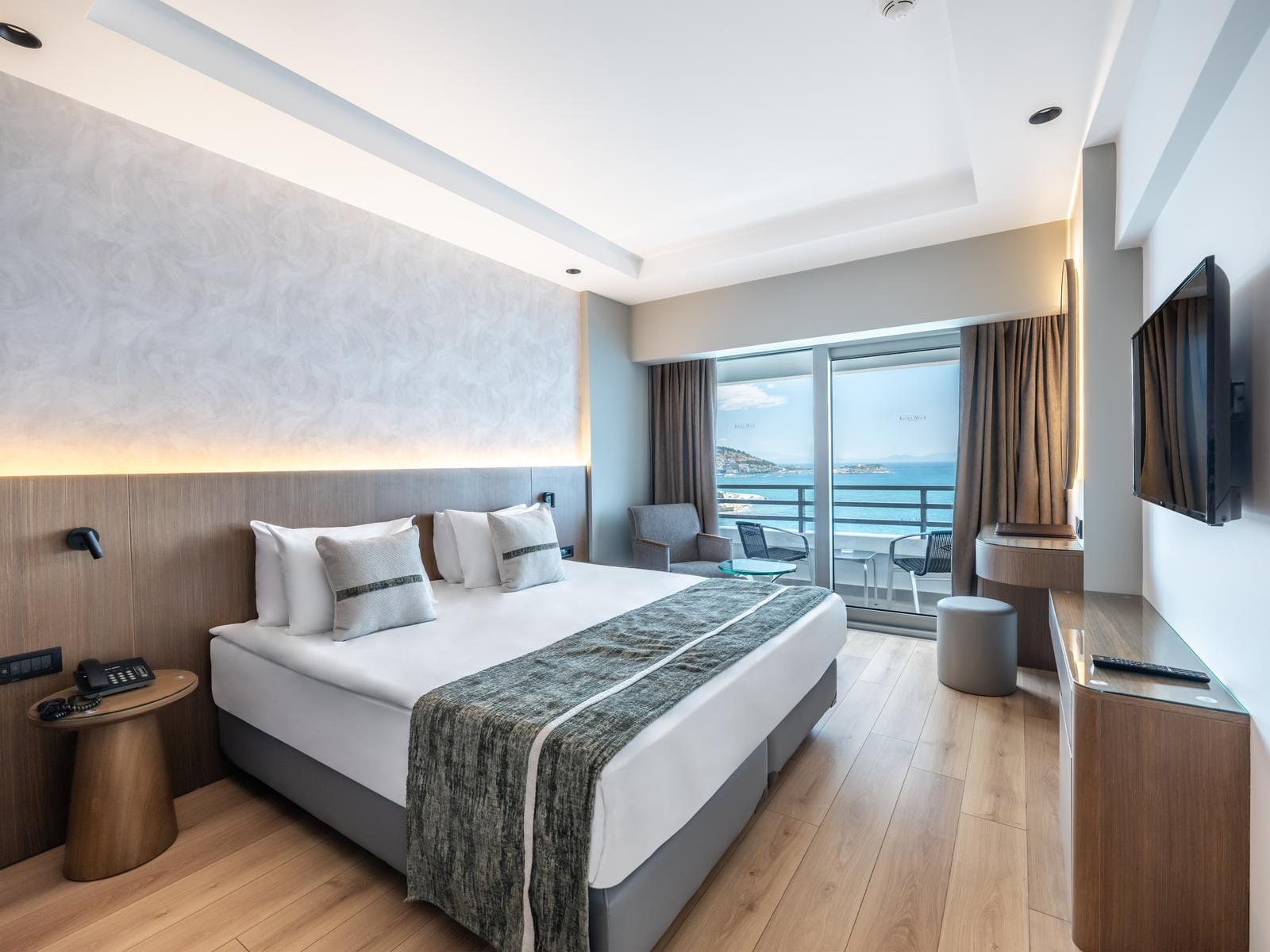 Modernes Hotelzimmer mit Meerblick, Doppelbett, Holzboden und stilvollen Details.