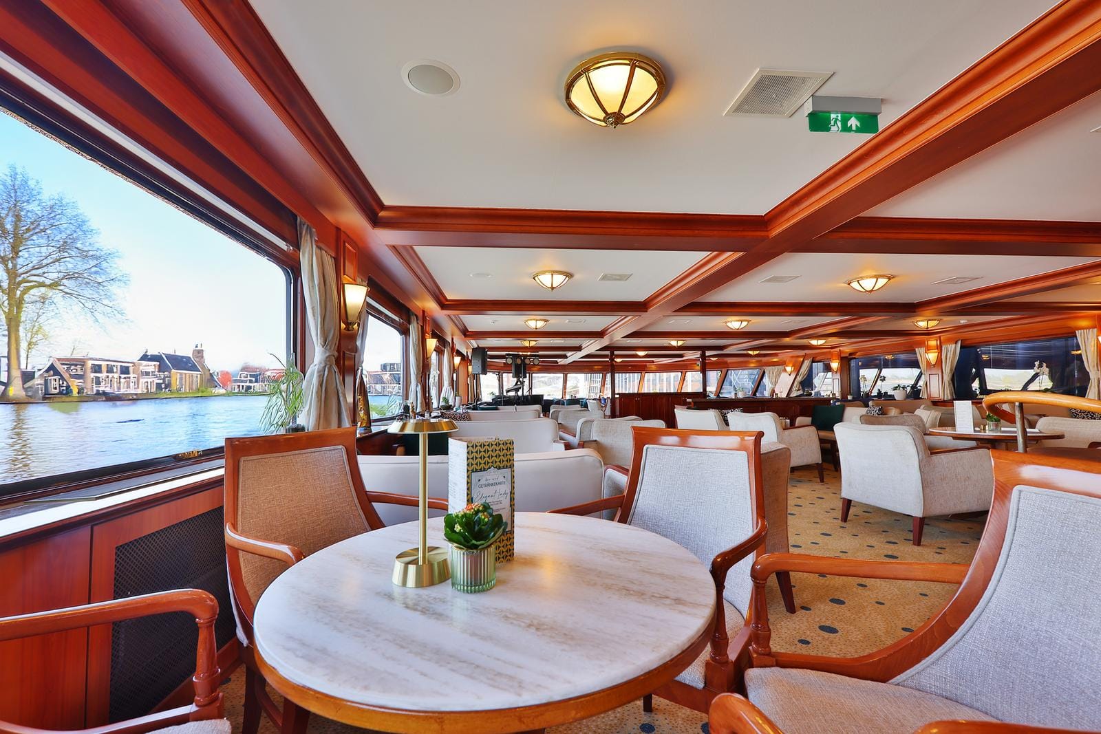Elegantes Restaurantschiff mit Holzakzenten, großer Fensterblick aufs Wasser.