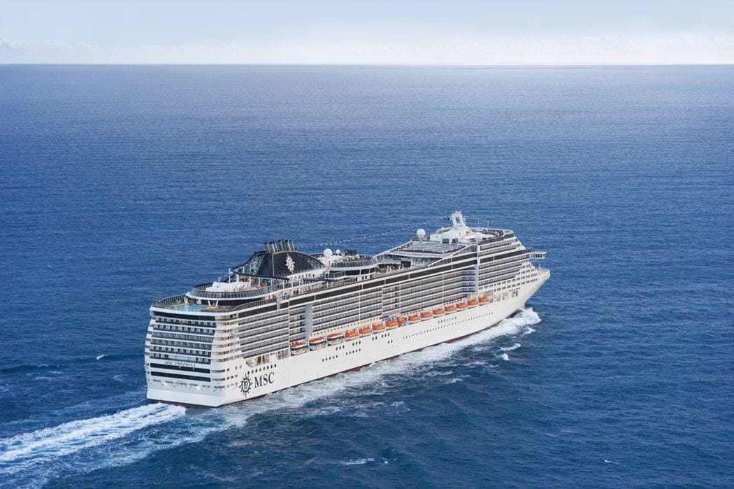 Großes Kreuzfahrtschiff auf ruhiger, blauer See unter klarem Himmel.