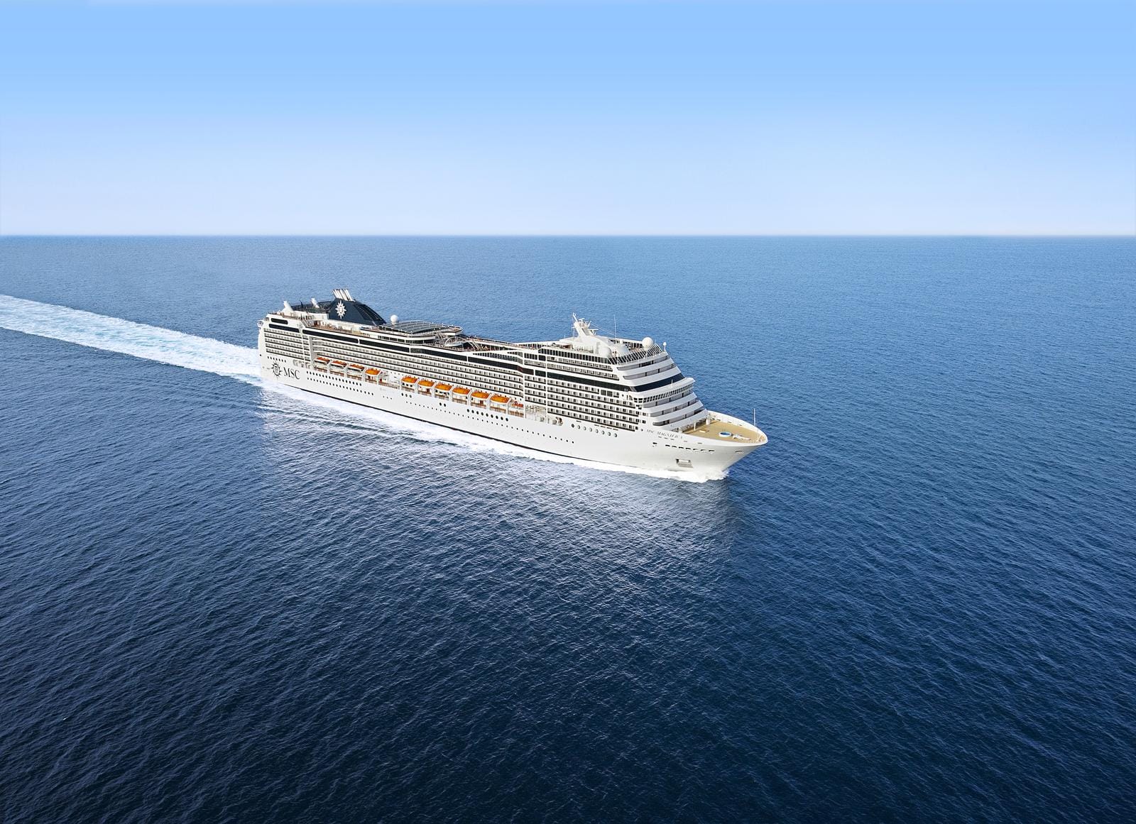 Ein großes Kreuzfahrtschiff fährt ruhig über das tiefblaue offene Meer.
