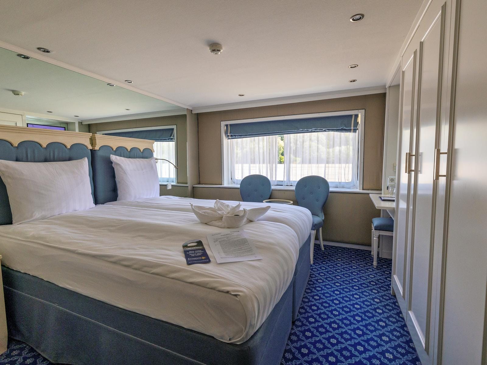 Modernes Hotelzimmer mit gemütlichem Bett, eventuell in Amsterdam, mit blauen Akzenten gestaltet.