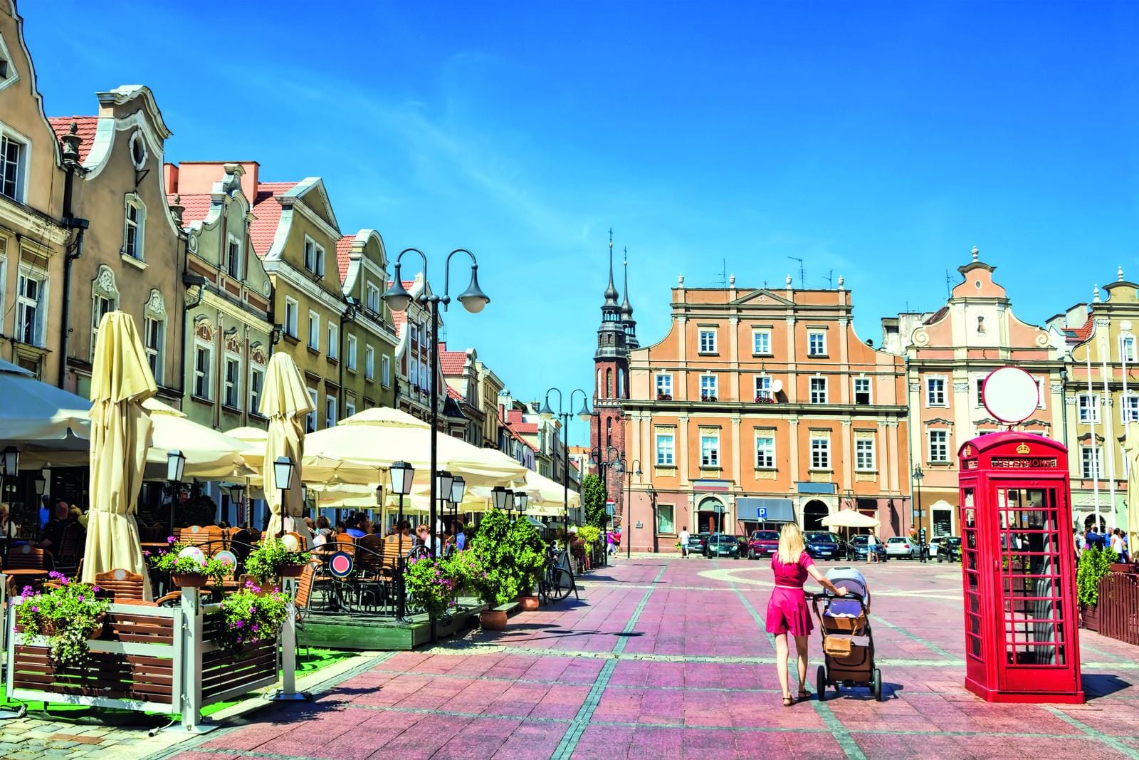 Historische Altstadt in Polen mit Cafés, roten Telefonzelle, blauen Himmel.