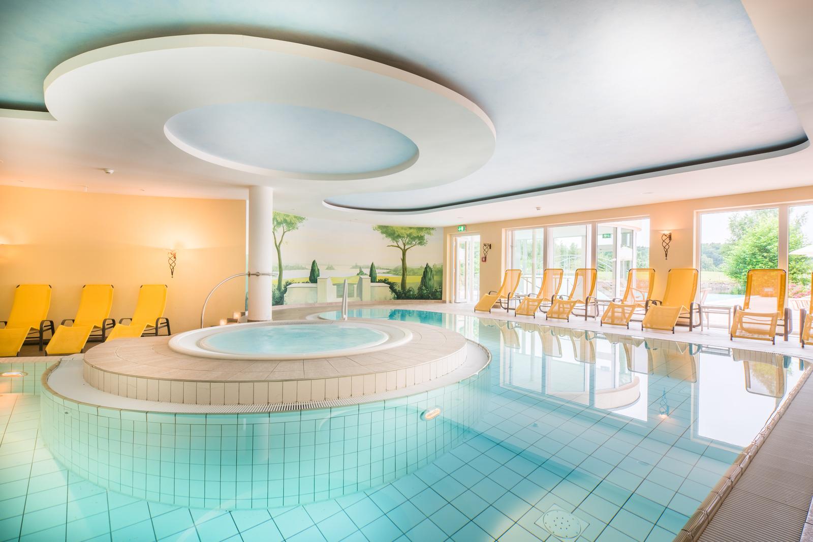 Modernes Hotel-Spa mit Pool und gelben Liegestühlen in heller, beruhigender Atmosphäre.