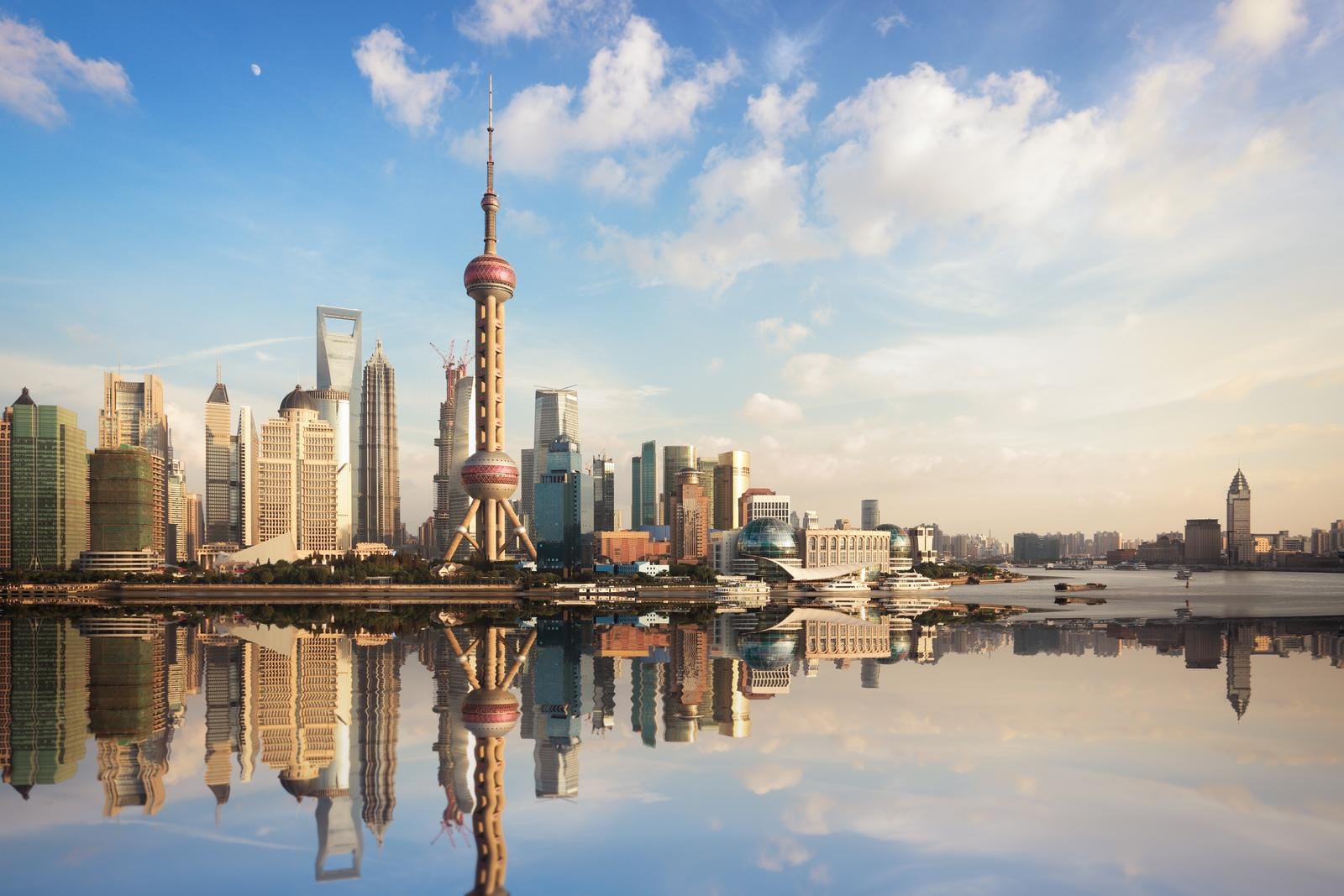 Shanghai, China mit Oriental Pearl Tower, moderne Skyline am Fluss bei klarem Himmel.