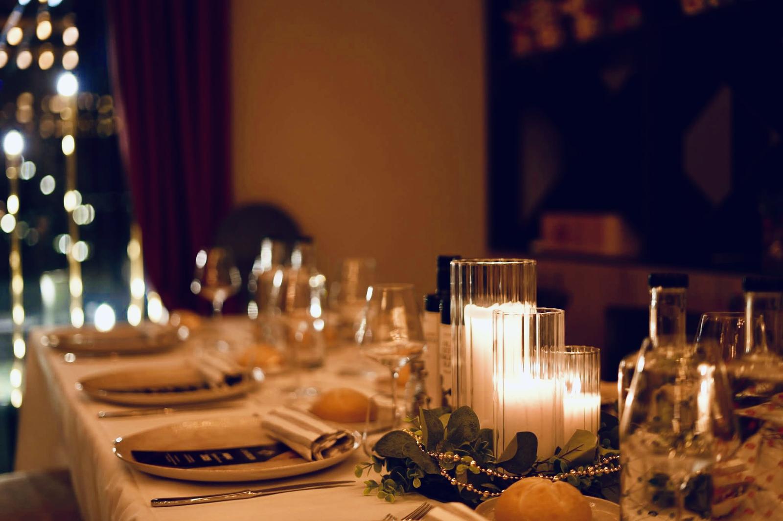 Elegant gedeckter Tisch mit Kerzenlicht und festlicher Dekoration.