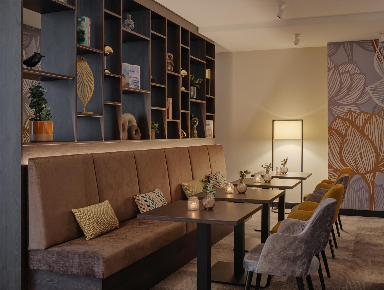 Gemütliche Hotel-Lounge mit warmen Erdtönen, modernen Möbeln und dekorativen Regalen.