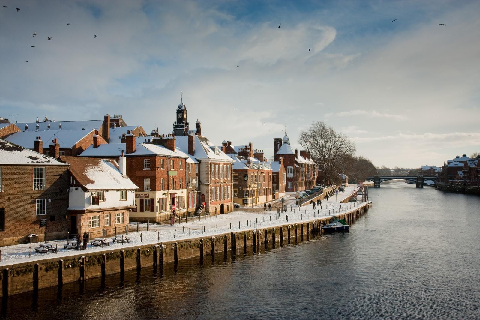 Verschneite Altstadt von York, England, am Fluss Ouse mit historischen Gebäuden.