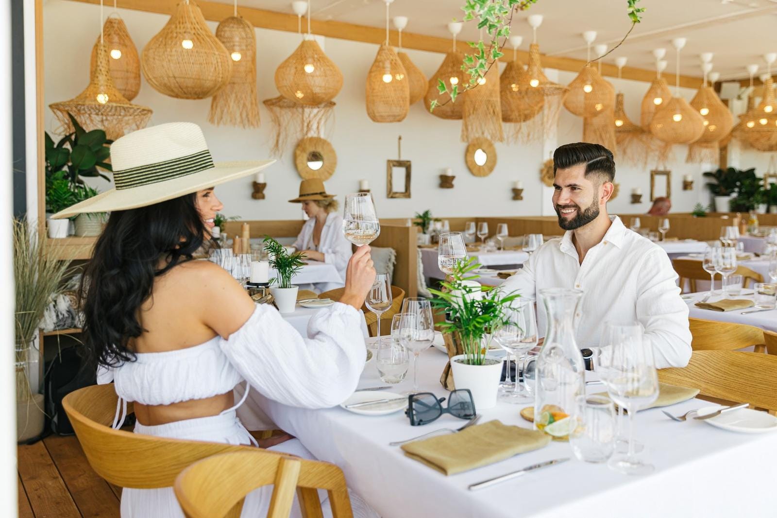 Modernes Restaurant mit Holzelementen, stilvollen Lampen und eleganten Gedecken.