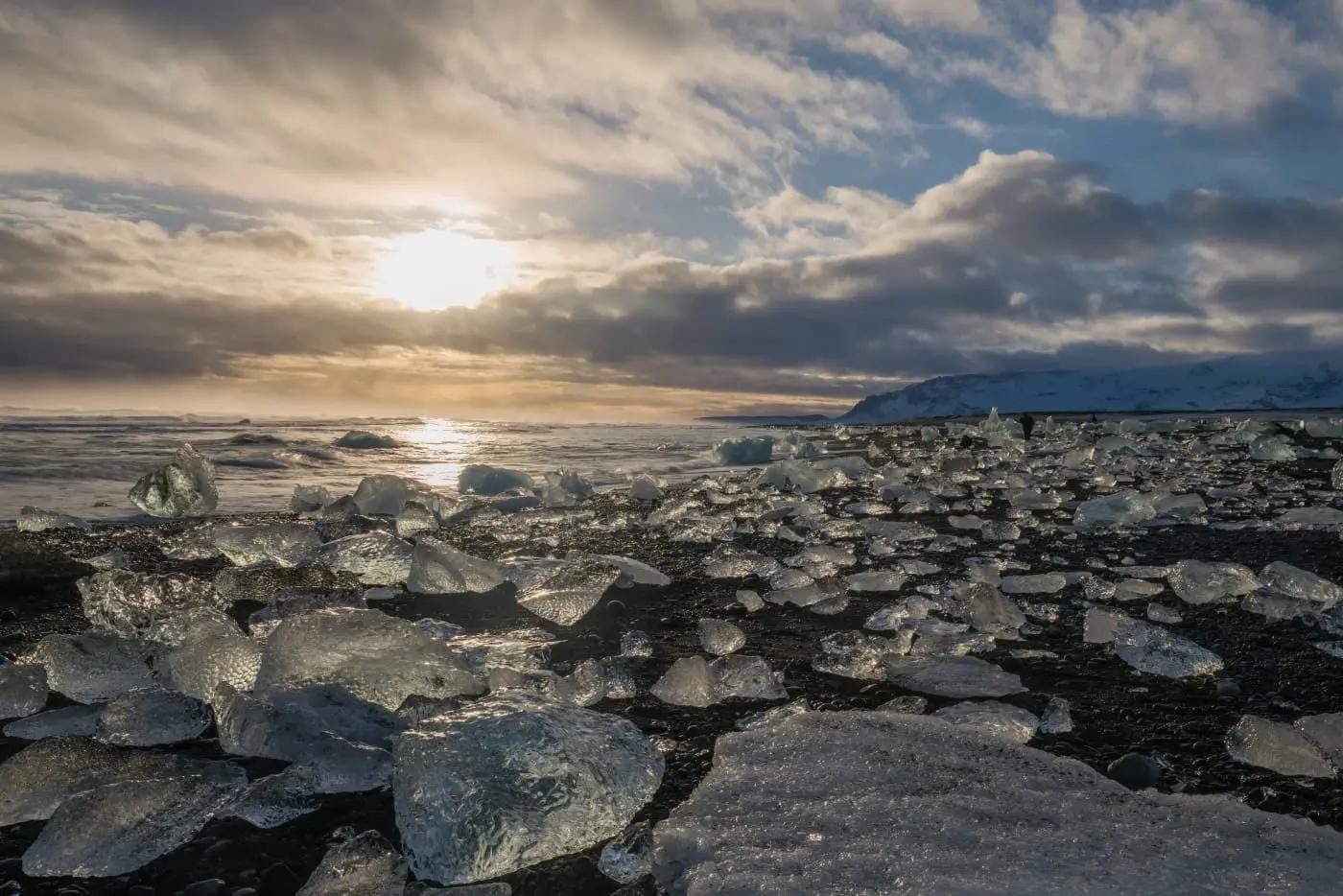 Eisbrocken am schwarzen Sandstrand in Island bei Sonnenuntergang.