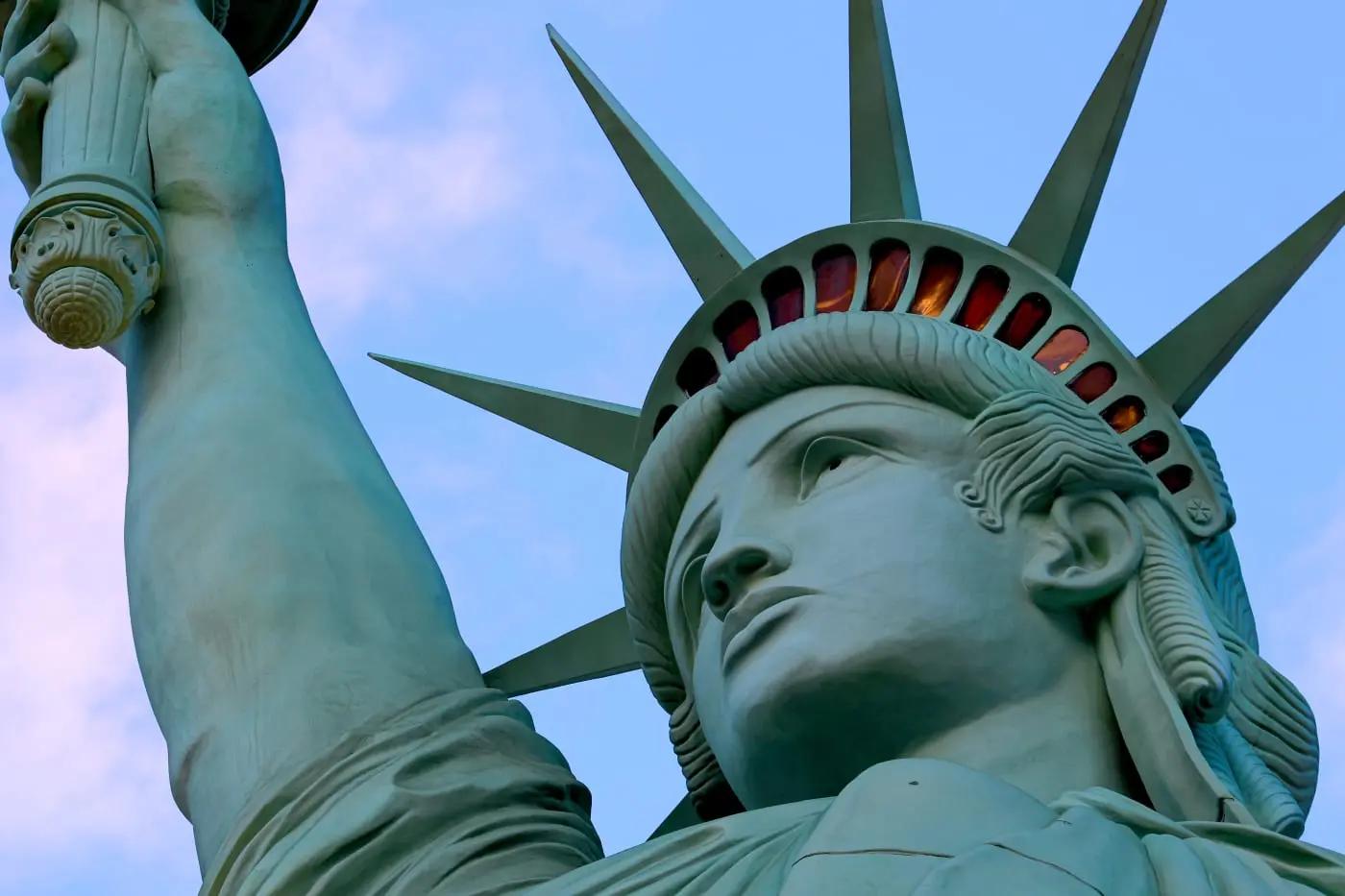 Nahaufnahme der Freiheitsstatue in New York, USA, mit blauem Himmel im Hintergrund.