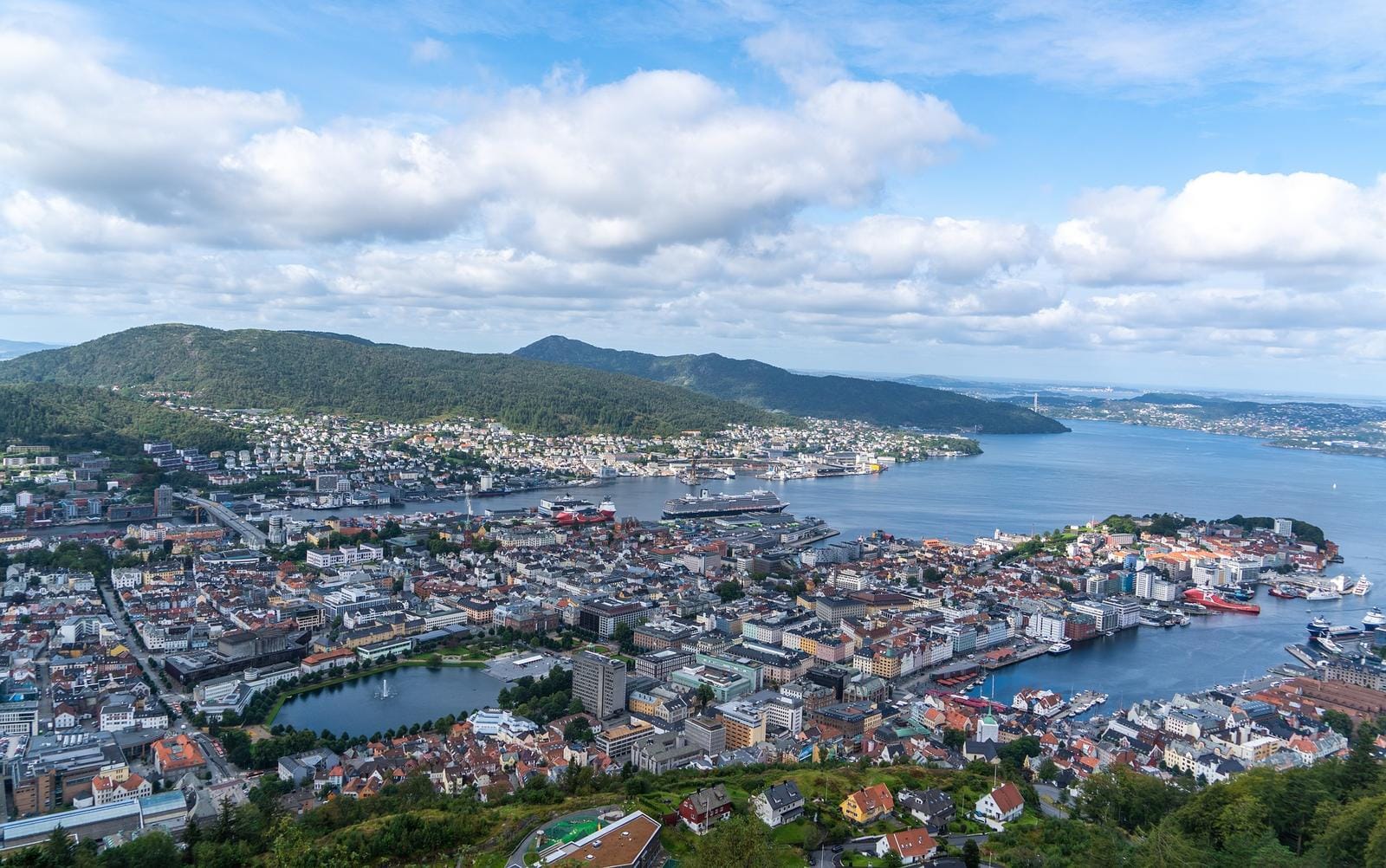 Panoramablick auf Bergen in Norwegen: Hafenstadt umgeben von grünen Hügeln und Wasser.