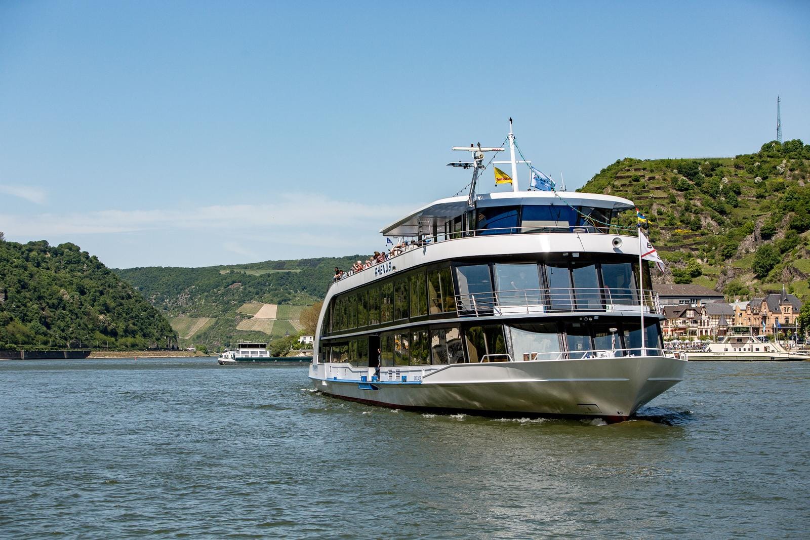 Kreuzfahrtschiff auf dem Rhein in Deutschland, umgeben von malerischen Hügeln und Weinbergen.