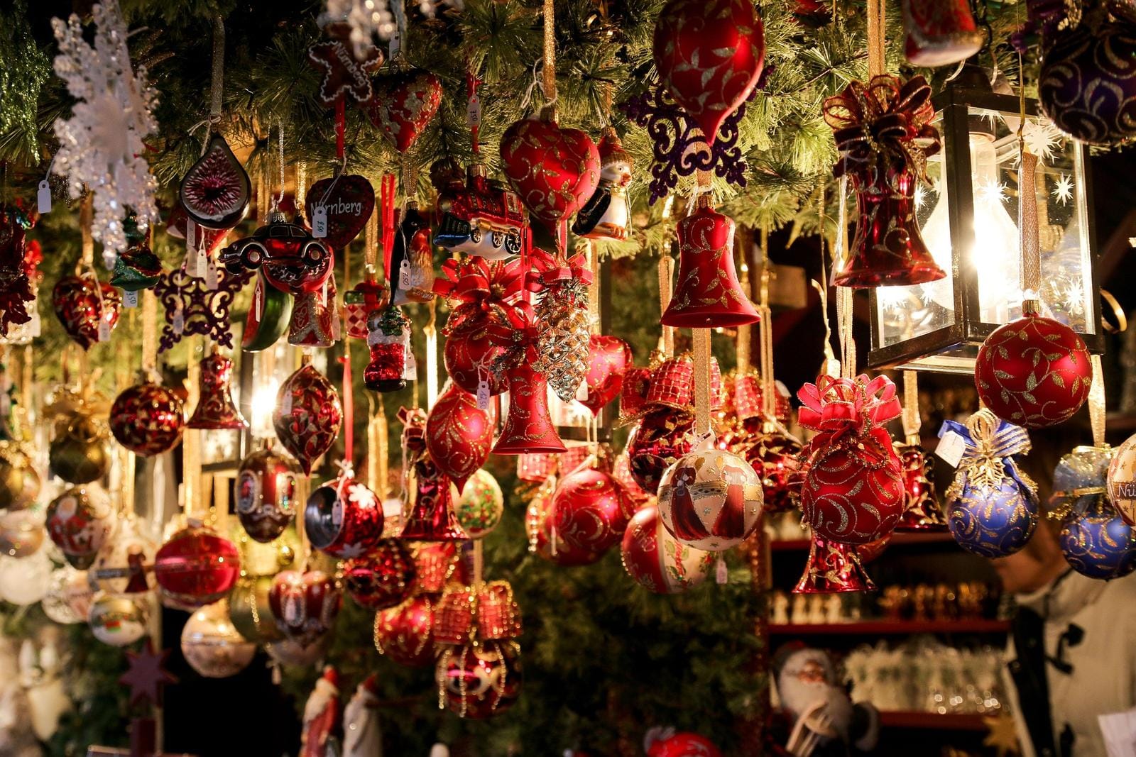 Weihnachtsdekorationen mit roten und goldenen Kugeln auf einem Weihnachtsmarkt.