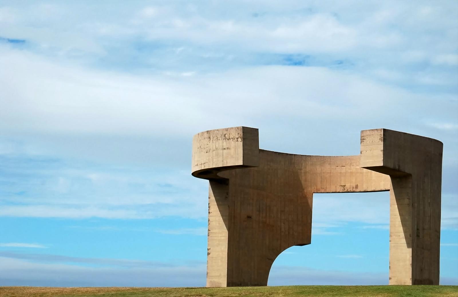 Betonskulptur "Elogio del Horizonte" in Gijón, Spanien, vor blauem Himmel.