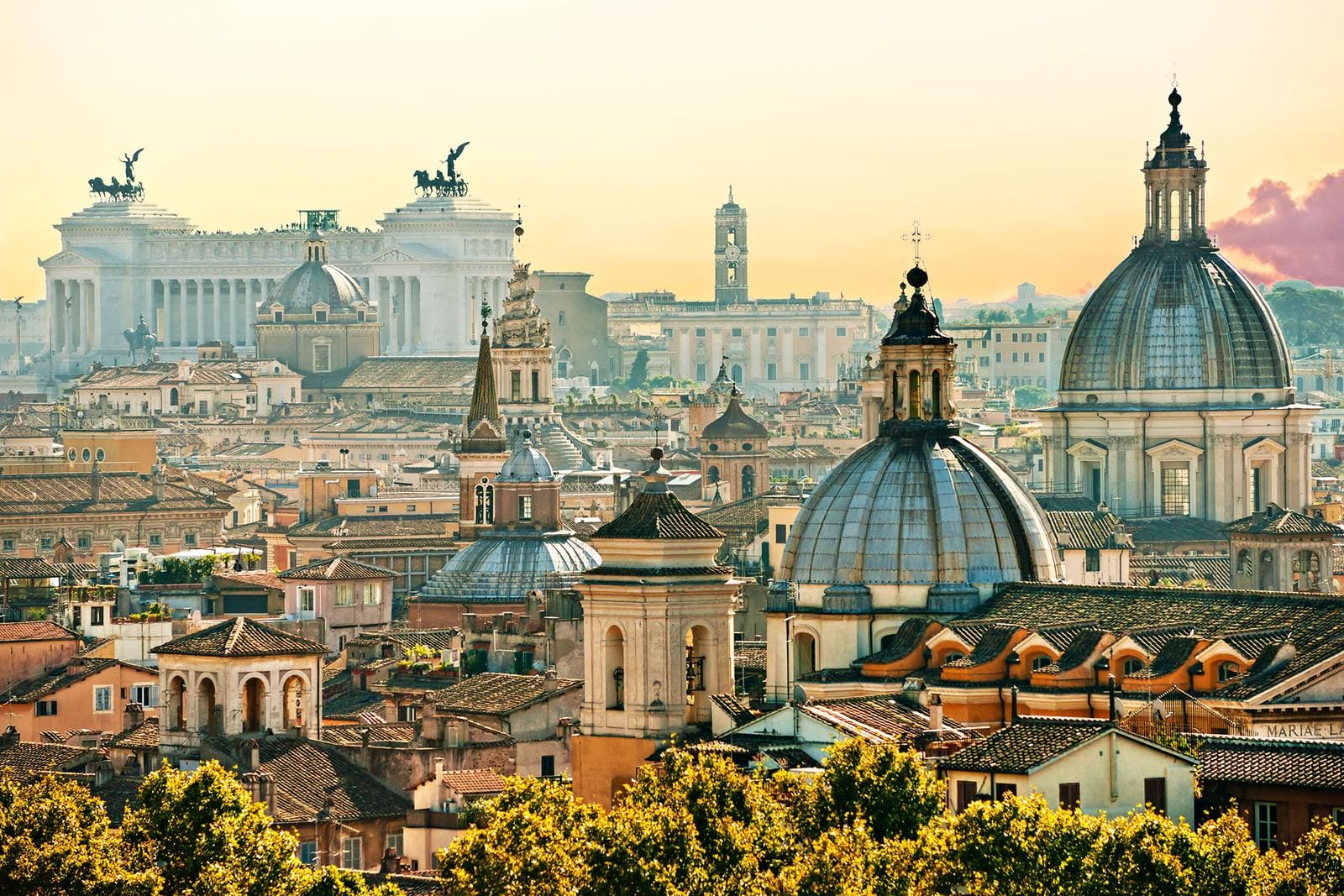 Panorama von Rom mit Kuppeln und dem Vittoriano im goldenen Abendlicht.